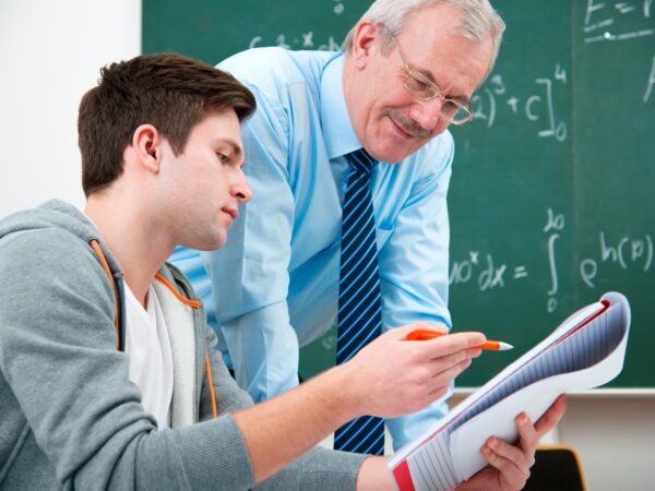stock-photo-male-student-with-a-teacher-in-classroom-110888624