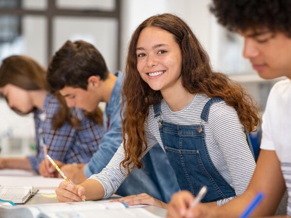 stock-photo-satisfied-young-woman-looking-at-camera-team-of-multiethnic-students-preparing-for-university-exam-1874731318
